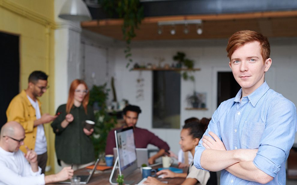 man-standing-beside-people-sitting-beside-table-with-laptops-31843951.jpg